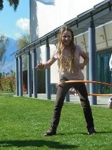 Girl with a hula hoop on the lawn outside a museum