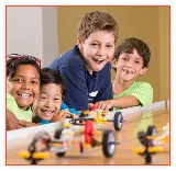 Kids building a LEGO car together at a children's museum