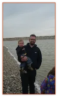 Dad holding a toddler on a lakeshore