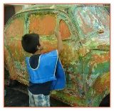 Boy painting a car at a children's museum art exhibit