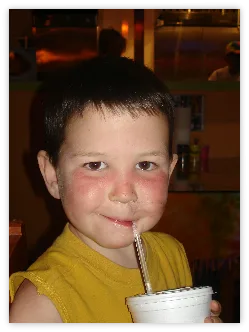 Boy drinking from a cup with a straw