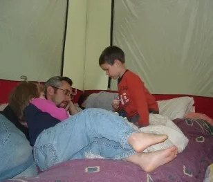 Dad and kids relaxing inside a tent