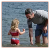 Dad and a little girl wading in a lake