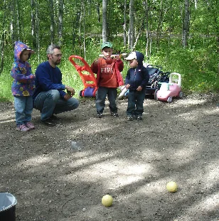 Family gathered around a campsite in the woods