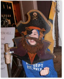 Boy with his face in a pirate cut-out board