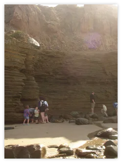 Family exploring a sea cave at the beach